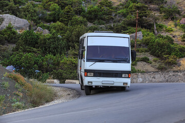 Tourist bus rides on a winding road in the mountains