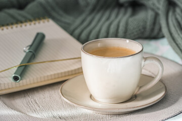 Cup of coffee and cookie on cozy bed. Warm wool sweater for a cozy autumn weekend, breakfast in bed, coffee break. Hygge concept.