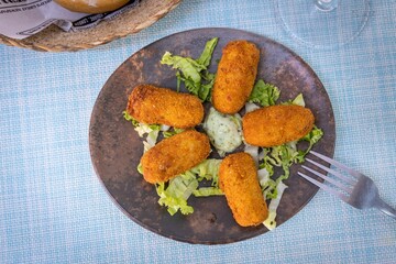 Plate of croquettes on a blue placemat