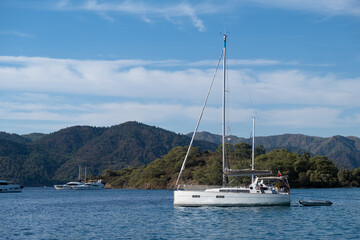 Fototapeta premium Beautiful bay with sailing boat, yacht in turquoise sea and mountains, luxury holidays or sailing regata sports.
