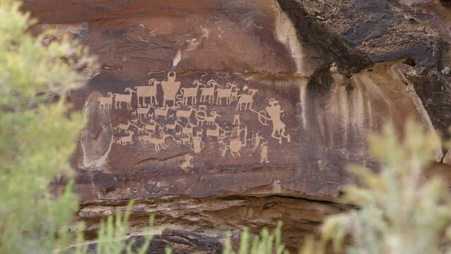 Viewing The Great Hunt Panel petroglyphs between sage brush in Nine Mile Canyon Utah.