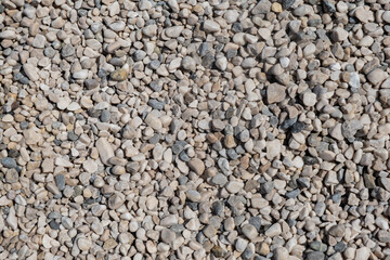 Stone gravel texture at a construction site or beach background warm colored pebbles