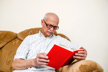 An elderly man reads the plan of the day in a glider book. Study business in retirement. An old man...