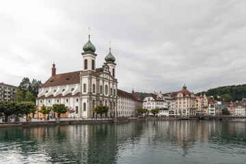 Fototapeta na wymiar City of Luzern, Switzerland, showing the church next to the famous Chapel Bridge reflected in the water