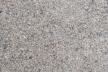 Stone gravel texture at a construction site or beach background gray colored pebbles