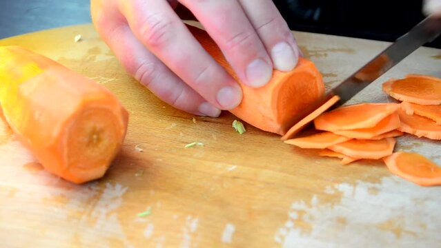 Cutting of carrots. The cook cuts carrots