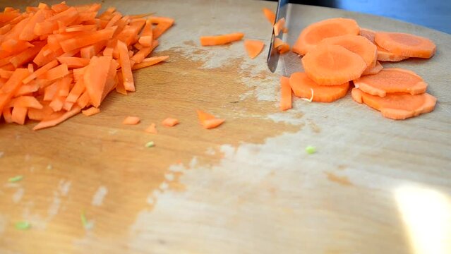 The cook cuts carrots. Cutting of carrots