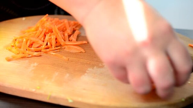 The cook cuts carrots. Cutting of carrots