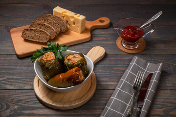 stuffed bell peppers with cheese and sliced bread on a wooden background