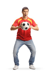 Excited young man holding a football and cheering