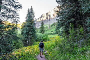 Man hiking with backpack on trail footpath to Ice lake in Silverton, Colorado in August early...