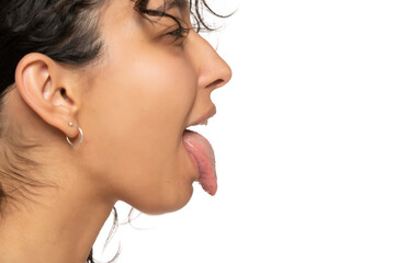 profile close up of young etnic woman with tongue out on a white background