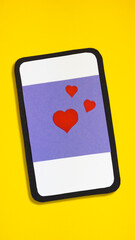 love concept. phone with a publication of three red hearts on a lilac background. paper craft minimal design on yellow background.