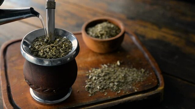 Serving traditional Argentinian yerba mate tea in a calabash gourd using hot water