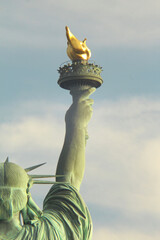 Statue of Liberty torch from behind with soft lighting and partly cloudy sky. Non-ai generated...