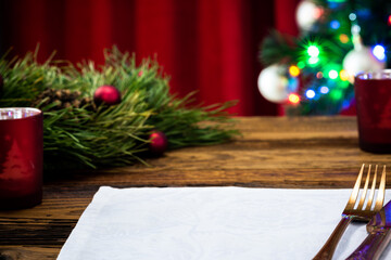 Festive Christmas table docorated, christmas tree in background