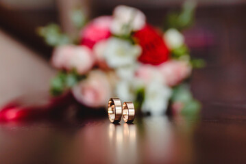 Obraz na płótnie Canvas wedding gold rings on the background of a bouquet