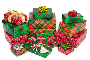 Pile of Christmas boxes with gifts in green and red checkered paper with bows on a white background