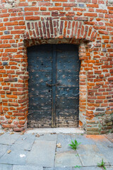 San Benigno Canavese, Piedmont, Italy - October 23, 2022: Door dating back to the Middle Ages.