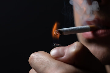 Smoking cigarette in the hand of young man close up