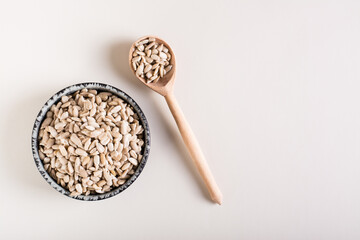 Peeled sunflower seeds in a bowl and in a glass jar on the table. Organic food. Top view