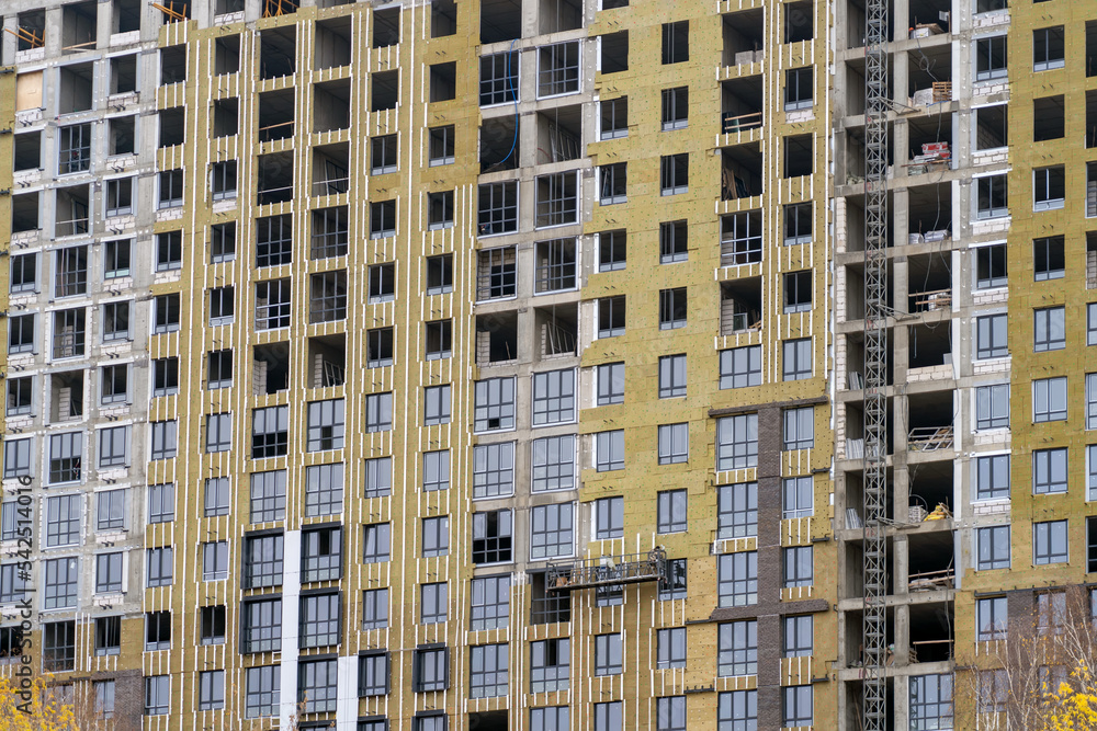 Poster installation of external wall thermal insulation with rock wool. monolithic concrete frame of apartm