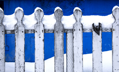 white picket fence in the snow