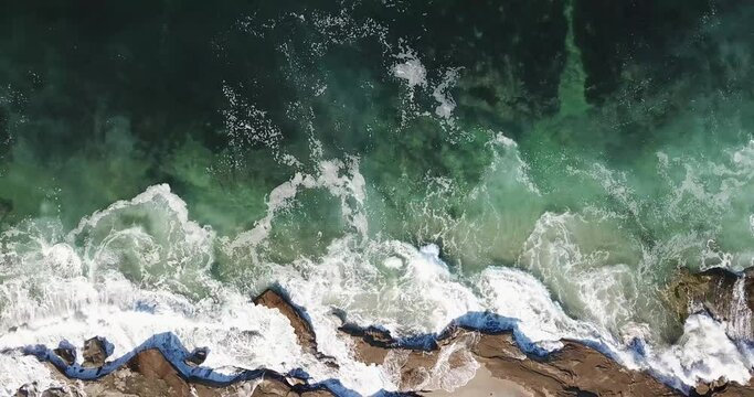 Pacific ocean waves lapping the jagged outcrops among the tide pools in La Jolla