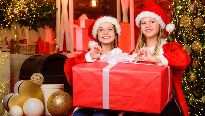 Obraz na płótnie Canvas Santa party. Happy new year. Children having fun on christmas eve. Giant enormous surprise. Winter masquerade. Happiness and joy. Santa crew. Girls friends sisters Santa claus costumes received gift