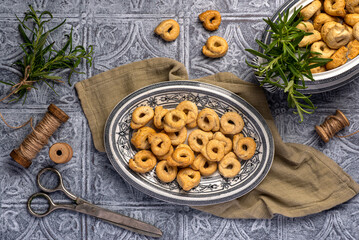 Food photography of taralli with rosemary, cracker, salty, bread, crunchy, crispy, rustic, homemade, baked, italian  