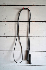 Generic, plastic jump rope hanging on a wooden wall