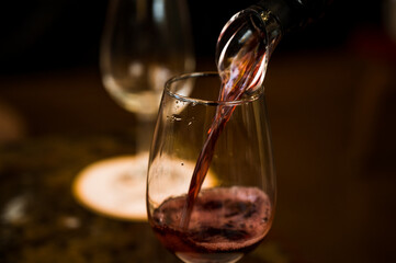 White sparkling wine from a bottle is poured into a glass goblet. Wine degustation. Close-up.