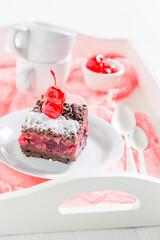 Brown chocolate cake with crumble and cherries