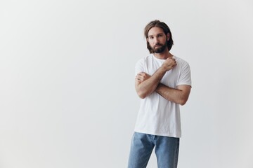 Portrait of a man with a black thick beard and long hair in a white T-shirt on a white isolated...