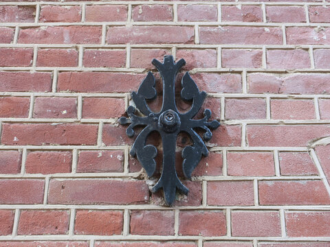 black painted wall anchor or wall clamp on a red brick wall