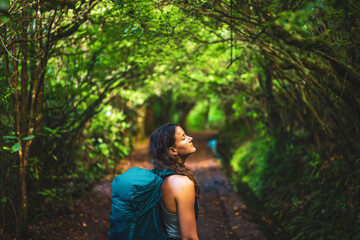 Beautiful woman enjoys beautiful calm forest athmosphere of the jungle. Levada of Caldeirão Verde,...