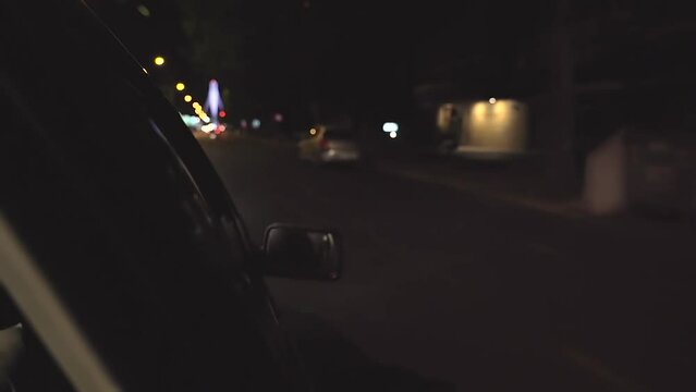 A masked killer throws a rifle out the car window at night. The killer is holding a rifle in the car at night. The killers in the car