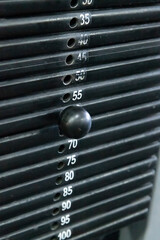 Close-up view of black stacked iron weight plates of exercise machine in gym. Selective focus. Copy...
