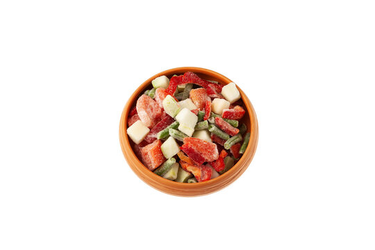 Different Frozen Vegetables in clay bowl on white background. Mexican mix. Concept - Freezing and proper defrosting of vegetables