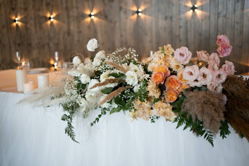 Romantic boho main table. Wedding decor with dried flowers floristry, stumps, and candles, boho style. Pampas grass