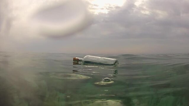 Message in a bottle. A message in a bottle floats on the surface of the sea. Bottle with message at sea