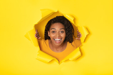 Woman Posing In Torn Paper Looking Through Hole, Yellow Background