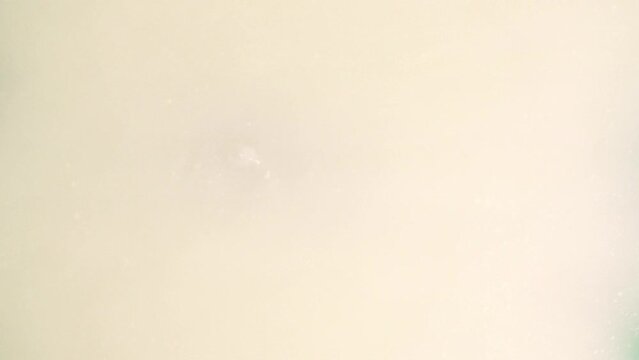 Top View Of A Woman's Face Coming Out From Under White Water, With Soap In The Water