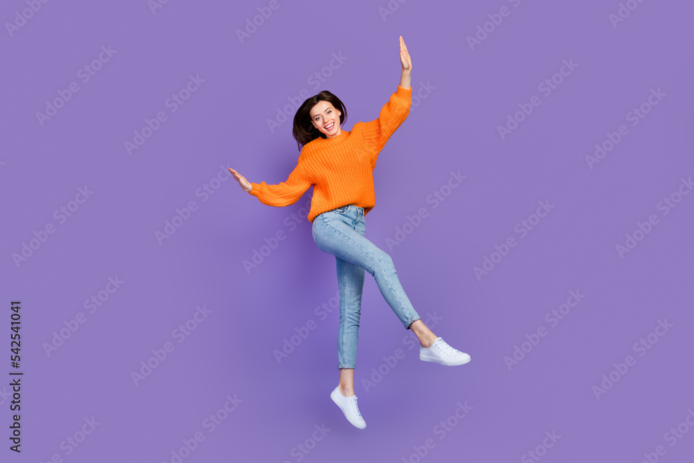 Sticker Full size photo of lovely young woman dancing jumping have fun wear trendy orange knitwear garment isolated on violet color background