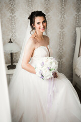 Luxury bride in white dress posing while preparing for the wedding ceremony