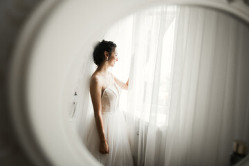 Luxury bride in white dress posing while preparing for the wedding ceremony