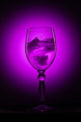 a glass with ice on a black background with light