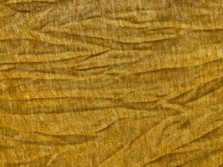 A yellow wrinkled wavy fabric surface