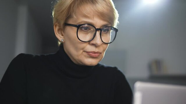High-qualified self confident blond woman restaurateur reading review on her restaurant and cuisine from famous critic on a popular food blog on laptop, feeling anger