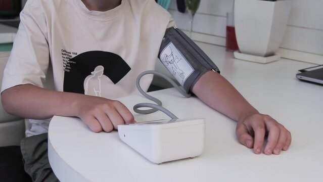 Electronic tonometer measures the pressure of a young man